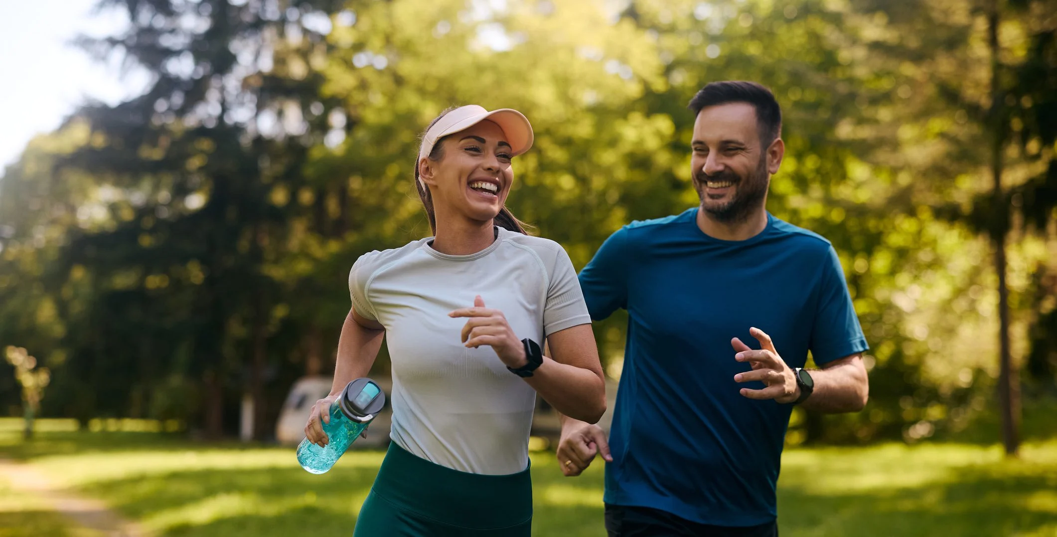 Cheerful Athletic Couple Jogging Through Park With Hearing Aids